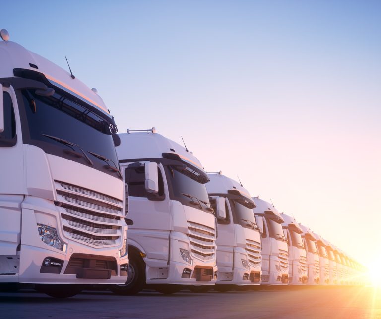 White commecial trucks lined up commercial insurance | Kuda